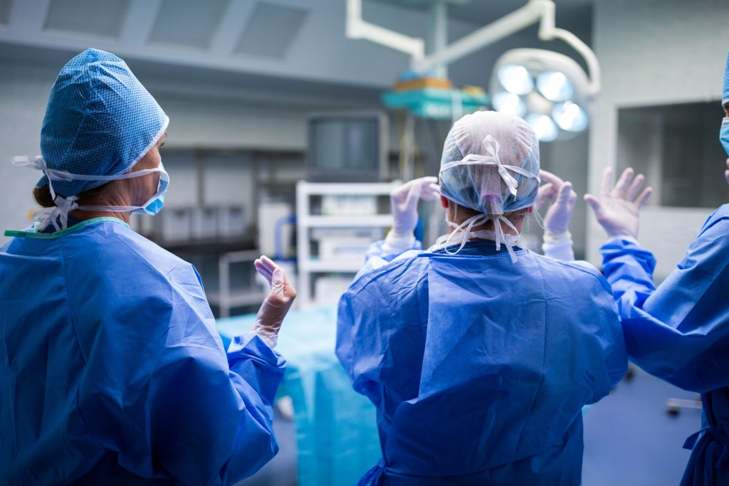 rear view of surgeons preparing for operation in operation room at the hospital