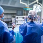 rear view of surgeons preparing for operation in operation room at the hospital