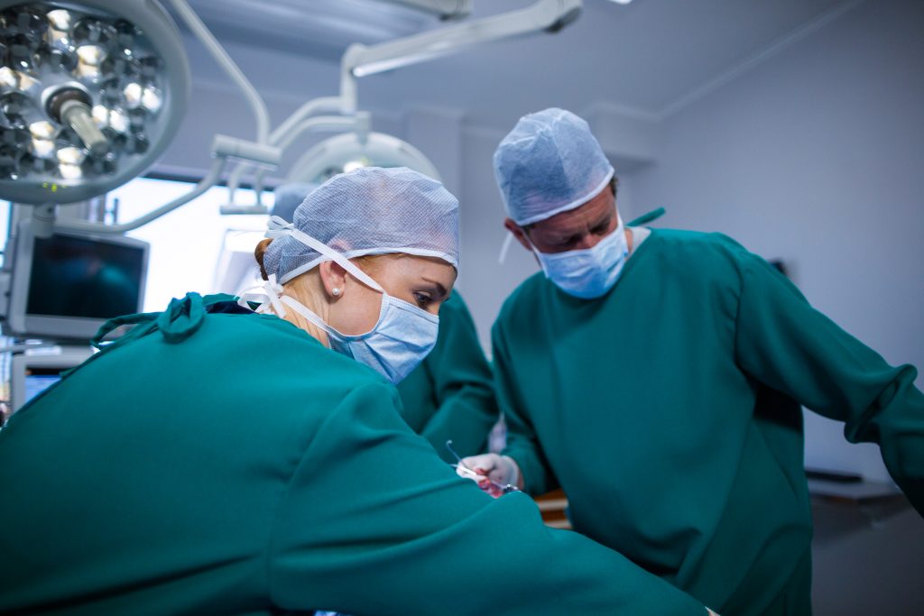 Surgeons performing operation in operation theater of hospital